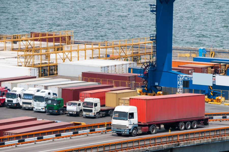 Shipping containers and diesel trucks staged at a New Jersey port terminal