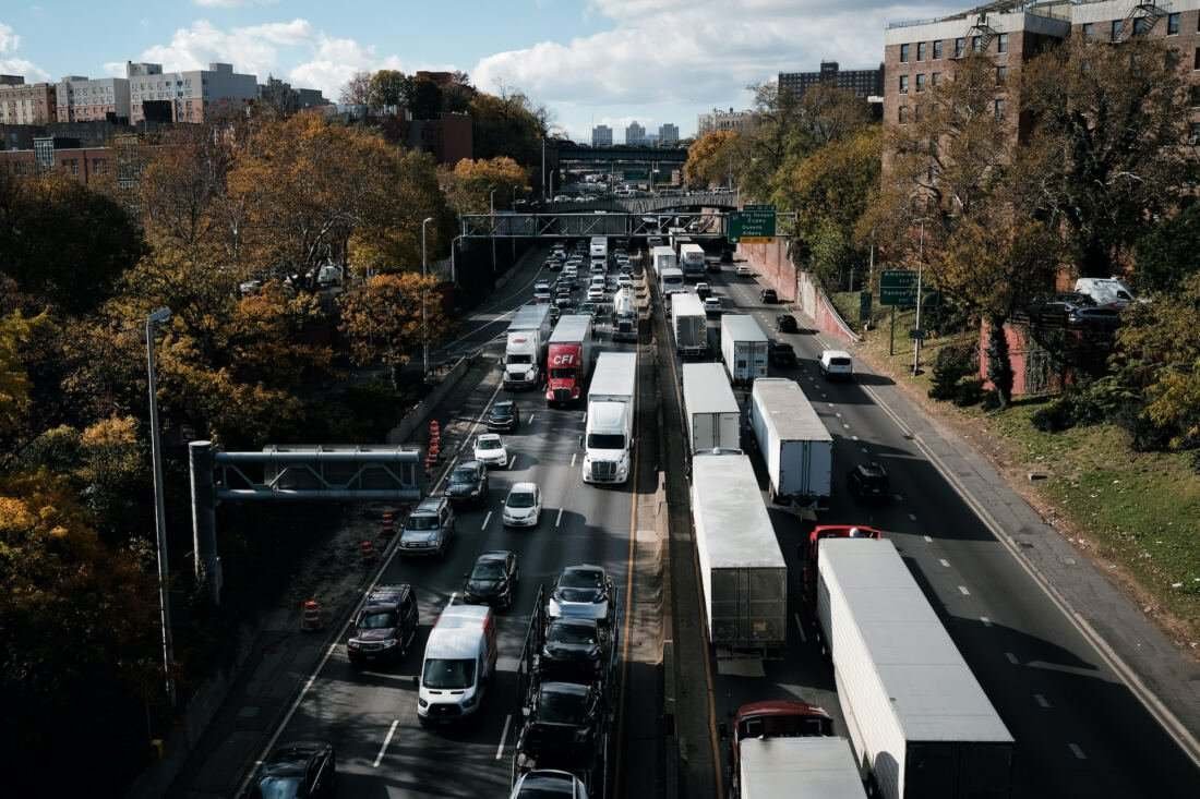 Port truck traffic idling on a dense highway corridor near residential apartment buildings